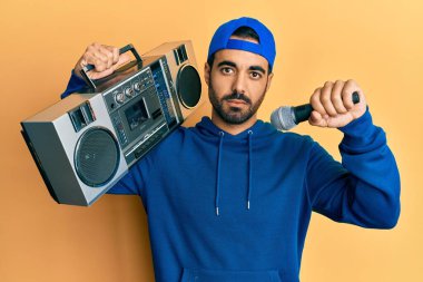 Kasetçalar tutan genç İspanyol adam mikrofonla şarkı dinlerken yüzünde ciddi bir ifade vardı. Basit ve doğal bir şekilde kameraya bakıyorsun.. 