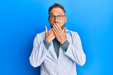 Doktor üniforması giyen yakışıklı orta yaşlı bir adam ve steteskop yanlışlıkla ağzı ellerle kapatmış. gizli kavram. 