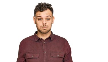 Günlük kıyafetler giyen genç İspanyol adam komik yüzlü yanakları şişiriyor. Havayla şişmiş ağız, çılgın bir ifade.. 