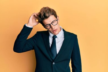 İş elbisesi ve kravat takan yakışıklı beyaz adam soru sorup şaşırıyor. Şüpheyle kararsız, kafa kafaya düşünerek. Düşünceli kavram. 