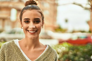 Güzel esmer kadın güler yüzlü mutlu ve kendinden emin sonbaharın güneşli bir gününde şehirde.