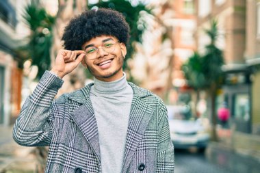 Genç Afrikalı Amerikalı iş adamı şehirde mutlu mesut dikiliyor..
