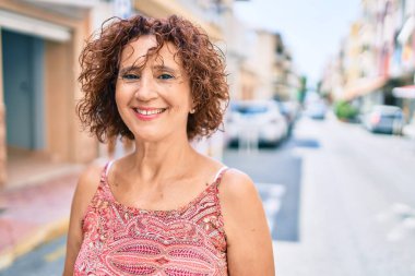 Orta yaşlı bir kadın gülümseyerek mutlu bir şekilde yürüyordu..