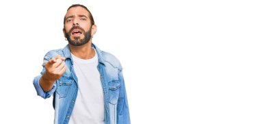 Uzun saçlı, sakallı, sıradan kot ceketli çekici bir adam kameraya kızgın ve sinirli olduğunu gösteriyor. 