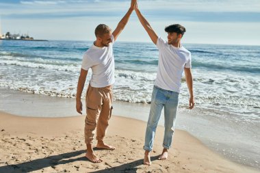 Genç eşcinsel çift gülümsüyor Kumsalda dans ederken mutlu.