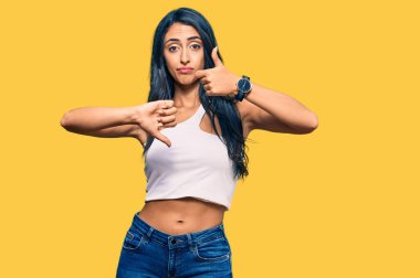 Güzel İspanyol kadın gündelik kıyafetler giyip başparmak kaldırıyor, anlaşmazlık ve uzlaşma ifadesi. çılgın çatışma 