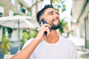 Şehirdeki akıllı telefondan konuşan, ciddi bir suratı olan genç bir Arap..