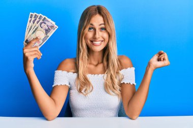 5000 Japon doları tutan güzel sarışın kadın gururla haykırıyor, zaferi ve başarıyı kutluyor. 