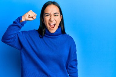 Asyalı genç bir kadın, öfkeyle bağırırken kızgın ve öfkeli bir şekilde elini kaldırıyor. öfke ve agresif konsept. 