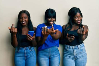 Akıllı telefon kullanan üç Afrikalı Amerikalı genç arkadaş. Buraya el kol hareketi yaparak mutlu ve gülümseyen insanları davet ediyorlar. 