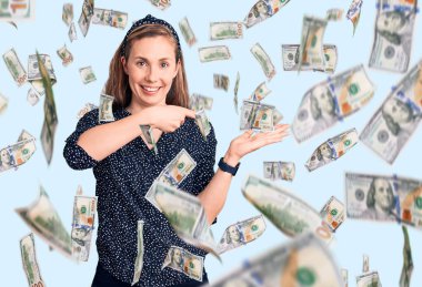 Genç ve güzel sarışın kadın, gündelik tişört giyip kameraya hayret ediyor ve gülümsüyor..