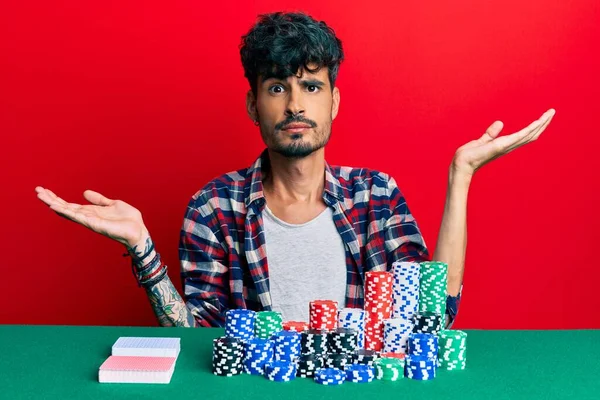 Jovem Hispânico Sentado Mesa Com Fichas Poker Cartas Sem Noção — Fotografia de Stock