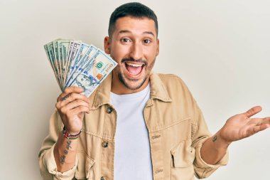 Dövmeli yakışıklı bir adam. Dolarlar elinde. Başarıyı mutlu bir gülümsemeyle kutluyor. 