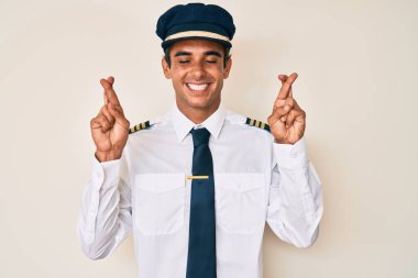 Uçak pilotu üniforması giyen genç İspanyol adam umut ve gözlerin kapalı gülümseyerek bana işaret ediyor. Şans ve batıl inançlar. 