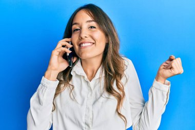 Genç esmer kadın akıllı telefonda konuşuyor. Deli gibi bağırıyor ve bağırıyor. Saldırgan bir ifade ve kollar havada. hüsran kavramı. 