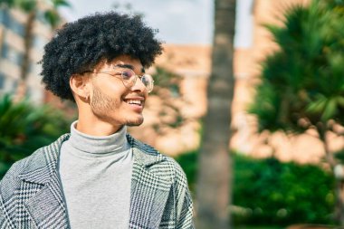 Genç Afrikalı Amerikalı işadamı parkta mutlu bir şekilde dikiliyor..