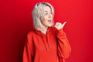 Gündelik kıyafetler giyen genç sarışın kız bir fikre ya da soru işaretine şaşırdı ve mutlu bir yüzle işaret etti. 