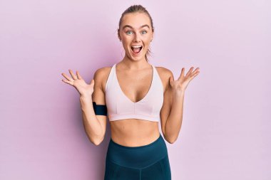 Spor giyim ve kol bandı takan güzel sarışın kadın çılgın kutlamalar yapıyor ve kolları açık, gözleri açık heyecanla haykırıyor. Kazanan konsept 