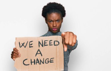 Elinde tutmakta olan Afrikalı genç bir Amerikalı kız kamerayı işaret eden bir değişim afişine ihtiyacımız var ve kendine güvenen, ciddi görünen bir jest. 