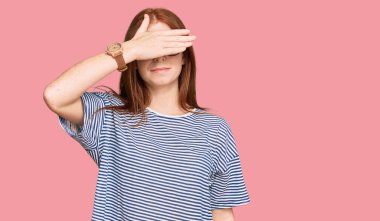 Gündelik kıyafetler giyen, gözlük takan, gözleri elle kaplayan, ciddi ve üzgün görünen genç okumuş bir kadın. Görme, saklama ve reddetme konsepti 