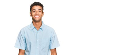 Genç, yakışıklı, Afro-Amerikalı, sıradan kıyafetler giyen mutlu ve havalı bir gülümsemesi olan bir adam. şanslı kişi. 