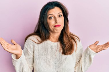 Gündelik giysiler giyen, kolları açık ve kafası karışık, hiçbir fikri olmayan, şüpheli yüzlü, güzel İspanyol bir kadın.. 