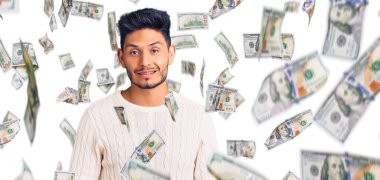 Yakışıklı Latin Amerikalı genç adam günlük kışlık süveter giyiyor. Pozitif ve mutlu görünüyor. Kendine güvenen bir gülümsemeyle dişlerini gösteriyor.