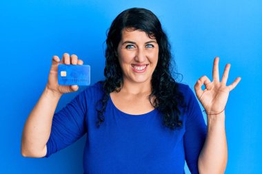 Ayrıca elinde kredi kartı olan esmer bir kadın parmaklarıyla imza atıyor, gülümseyerek mükemmel bir sembol oluşturuyor. 
