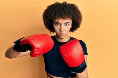 Genç İspanyol sporcu kız boks eldiveni kullanıyor şüpheci ve gergin, sorun yüzünden surat asıyor. negatif kişi. 