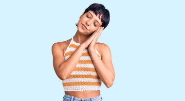 Kısa saçlı genç esmer kadın günlük kıyafetler giyiyor. Uyuyor, yorgun. Hayal kuruyor, el ele poz veriyor ve gözleri kapalı gülümsüyor.. 