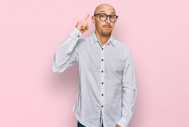 İş gömleği giyen ve gözlüklü kel bir adam başarılı bir fikri işaret ediyor. Heyecanlı ve mutlu. Bir numara.. 