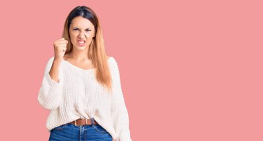 Güzel, genç bir kadın, öfkeyle bağırırken kızgın ve kızgın bir şekilde yumruğunu kaldırıyor. öfke ve agresif konsept. 