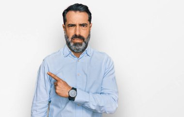 Sakallı, iş gömleği giyen orta yaşlı bir adam endişeli, endişeli ve şaşırmış bir ifade takınıyor. 