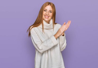 Genç İrlandalı kadın, sıradan bir kazak giyiyor, alkışlıyor, alkışlıyor, mutlu, mutlu ve gururlu elleri bir arada. 