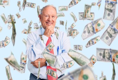 Zarif kravat ve tişört giyen yakışıklı bir adam kameraya kendinden emin bakıyor kollarını kavuşturup gülümseyerek ve çenesini kaldırarak. Olumlu düşünmek.