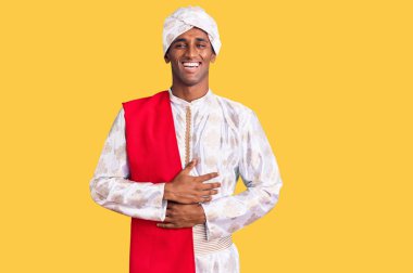 Gelenek giyinmiş Afrikalı yakışıklı bir adam Sherwani sari elbiseleri giyiyor. Gülerek kahkahalar atıyorlar.. 