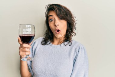 Genç İspanyol kadın bir bardak kırmızı şarap içiyor. Korkmuş ve şaşırmış bir şekilde ağzı açık, inançsız bir yüz. 