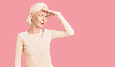 Gündelik kıyafetler giyen genç sarışın kadın çok mutlu ve gülümsüyor. arama kavramı. 