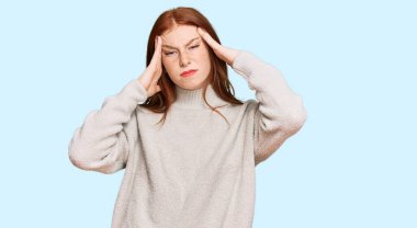 Baş ağrısı ve baş ağrısından muzdarip sıradan bir kazak giyen genç, okumuş bir kadın. Eller başının üstünde.. 