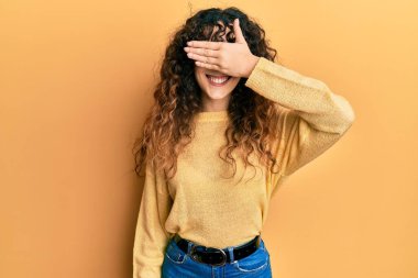 Günlük kıyafetler giyen, gülümseyen ve gülen genç İspanyol kız şaşırmak için gözlerini kapatıyor. kör kavram. 