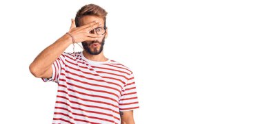 Sakallı, sıradan kıyafetler giyen ve gözlüklü yakışıklı bir adam. Şok içinde, yüzünü ve gözlerini kapayarak utangaç bir ifadeyle parmaklarının arasından bakıyor.. 