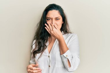 Güzel bir ortadoğulu kadın günlük kıyafetler giyip pis ve iğrenç bir koku alıyor. Nefesini burnu havada tutuyor. Kötü kokuyor. 