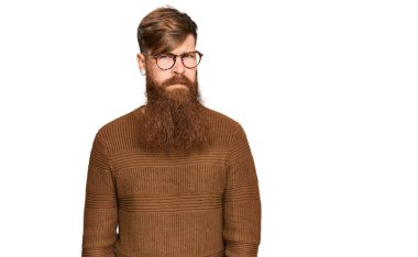 Sıradan kıyafetler giyen, gözlüklü, kuşkucu ve gergin genç İrlandalı bir adam sorun yüzünden surat asıyor. negatif kişi. 