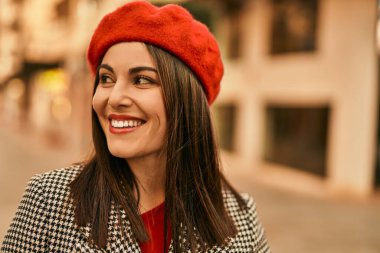 Genç İspanyol kadın gülümseyerek şehirde mutlu mesut dikiliyor..