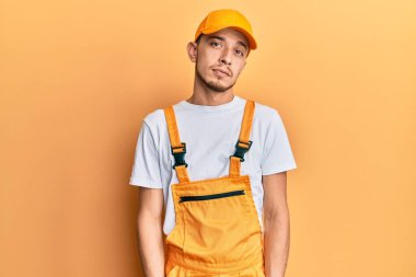 Tamirci üniforması giyen İspanyol genç adam uykulu ve yorgun görünüyor, yorgunluktan bitkin ve akşamdan kalma, sabahları tembel gözler.. 