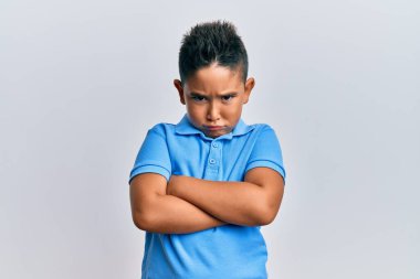 Gündelik kıyafetler giyen, kuşkucu ve gergin bir çocuk. Yüzünde çapraz kollu tasvip etmeyen bir ifade var. negatif kişi. 