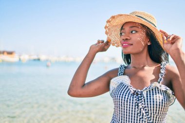 Genç Afrikalı Amerikalı kadın tatilde. Kumsalda mutlu bir şekilde yürüyordu.