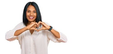 Genç Afro-Amerikan kadın gündelik giysiler giyiyor. Aşık gülümsüyor. Elleriyle kalp sembolü ve şekli gösteriyor. romantik kavram. 