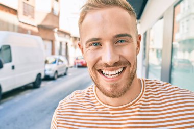 Genç İrlandalı adam gülümsüyor. Şehrin caddesinde mutlu bir şekilde yürüyor..