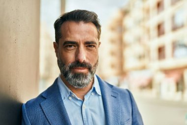 Şehirde duran rahat yüzlü orta yaşlı iş adamı..